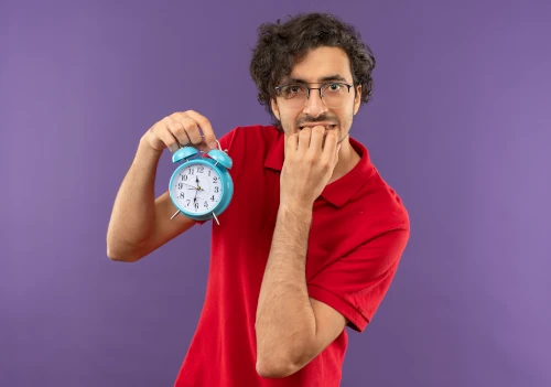 Illustration d’un utilisateur impatient devant un réveil pour représenter la lenteur d’un site web et la perte de visiteurs.