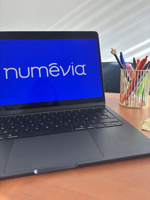 Ordinateur portable affichant le logo Numévia, environnement de travail pour coaching WordPress